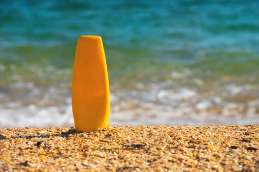 Sunscreen lotion on a tropical beach. Close-up of a tube of moisturizer, space for label or advertising, mockup for perfumery.