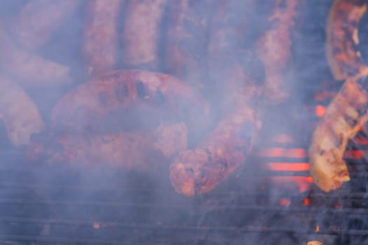 Grilling sausages on barbecue grill. Delicious sausages on charcoal grill