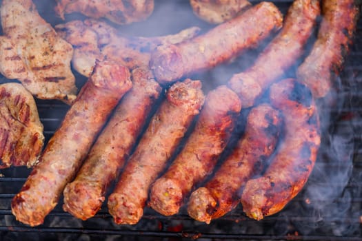 Grilling sausages and pork chops on barbecue grill. BBQ in the garden