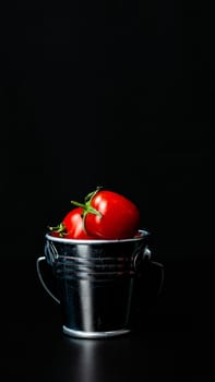 Selective focus on composition with mini decorative bucket and tomatoes. Small metal bucket with cherry tomatoes