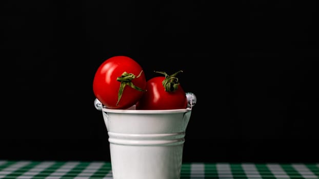 Selective focus on composition with mini decorative bucket and tomatoes. Small metal bucket with cherry tomatoes