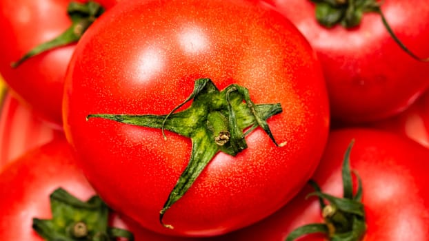 Close up of ripe red tomato, tomatoes background.