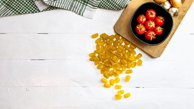 Pasta ingredients isolated. Cherry tomato, pasta, garlic and onions