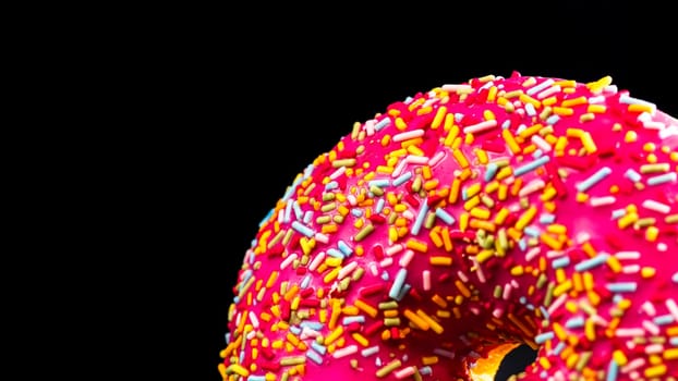 Pink glazed donut with sprinkles isolated. Close up of colorful donut.