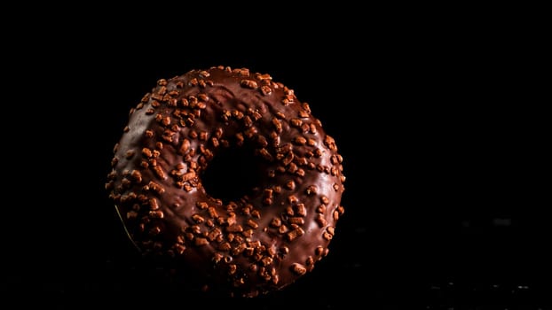 Chocolate glazed donut with chocolate chips isolated. Close up of delicious donut.