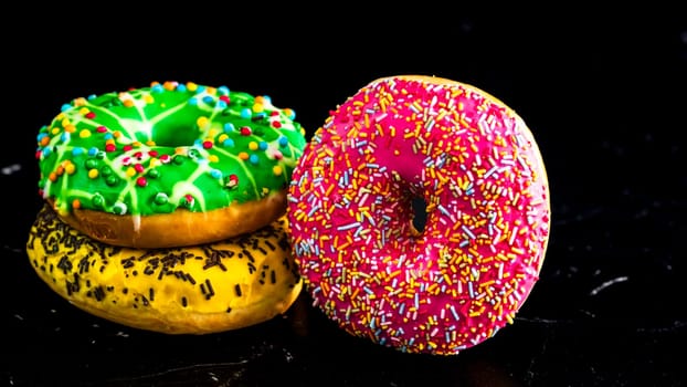 Glazed donuts with sprinkles isolated. Close up of colorful donuts.