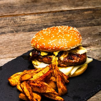 Tasty home made cheeseburger. Cheese burger with pickles, tomatoes, onion, melting cheese