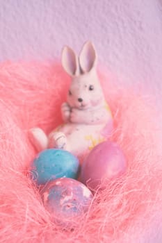Space galactic Easter eggs in a pink nest next to a rabbit