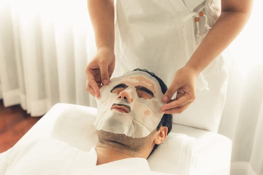 Serene modern daylight ambiance of spa salon, woman customer indulges in rejuvenating with facial skincare mask. Facial skin treatment and beauty cosmetology procedure for face. Quiescent