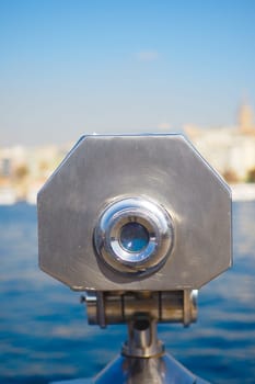 Coin-operated binoculars looking out over city buildings