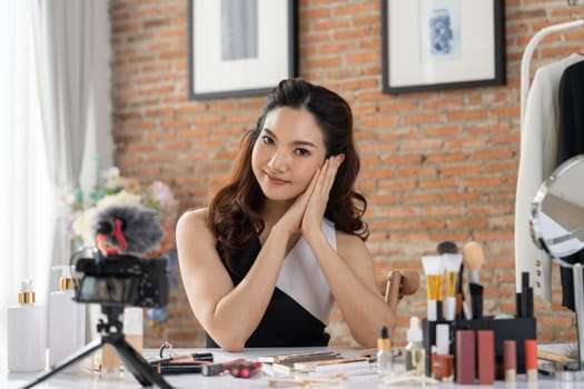 Asian Woman influencer shoot live streaming vlog video review makeup uttermost social media or blog. Happy young girl with cosmetics studio lighting for marketing recording session broadcasting online