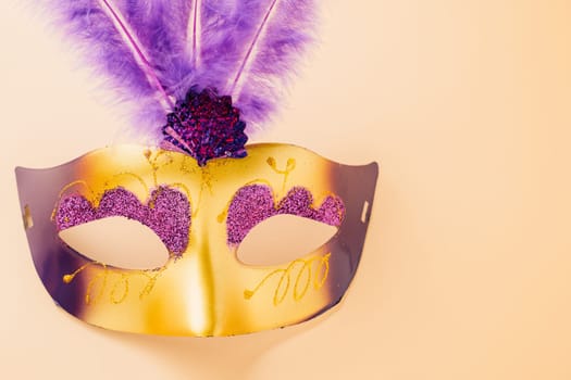 Happy Purim carnival decoration. Jewish Purim and Mardi Gras in Hebrew, Top view venetian ball mask with purple feather on pastel background, holiday background banner design, Masquerade party