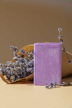 Lavender soap on beige background with copy space for your text. Advertisement template mock up. Skincare homemade natural cosmetic concept. Organic dry lavender flower. Handmade soap