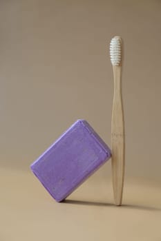 Zero waste bamboo toothbrush and Handcrafted purple lavender soap with lavender flowers. Natural hydrating moisturiser softness cosmetic. Organic calming beauty skincare product. Herbal self care wellness alternative soap. Copy space