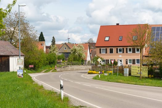 Weinberg, Germany - May 6, 2023: Houses along the road, cars in a German village.