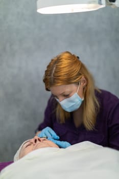 The medical lamp accurately illuminates the treatment field. The patient lies down while the doctor performs subcutaneous injections.