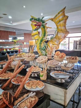 The buffet in the restaurant with a variety of dishes is decorated with the image of a dragon