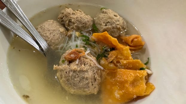 super delicious, tender and juicy and spicy bites of beef tendon meatballs in a bowl in Indonesian street food