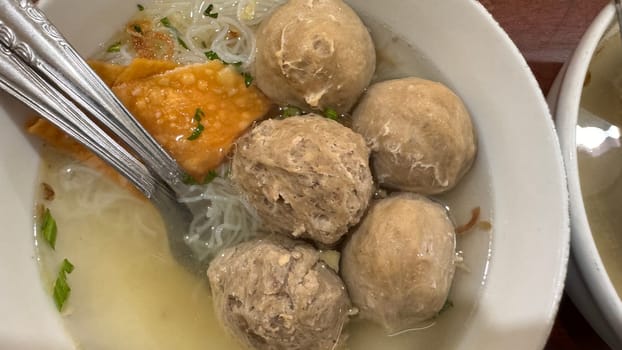 super delicious, tender and juicy and spicy bites of beef tendon meatballs in a bowl in Indonesian street food