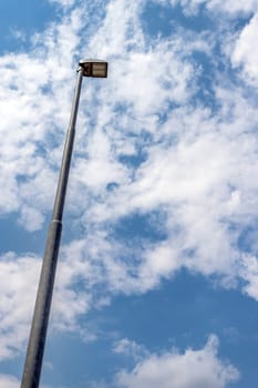 LED street lamp post on blue sky background with white clouds