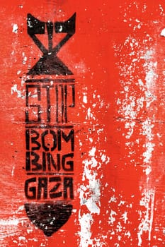 Graffiti on the red grungy wall depicting the silhouette of a bomb. Inside message: STOP BOMBING GAZA. Copy space. Fully editable.
