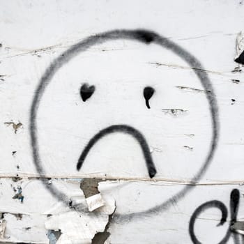 Sad smile painted on the wall. Concepts and backgrounds.