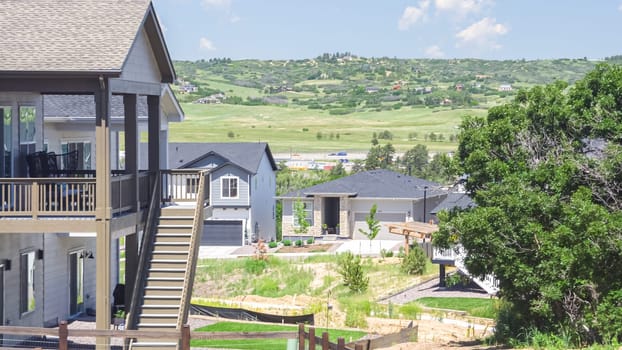 In the summertime, a scenic view unfolds, showcasing newly built residential homes in Castle Rock, Colorado, surrounded by lush greenery and a serene ambiance.