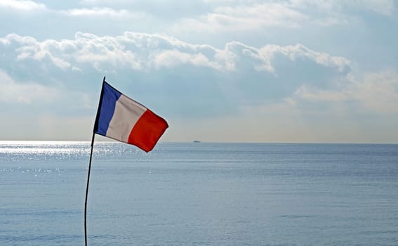 France flag on pole against blue cloudless sky in daylight. France flag waving on white background, long shot