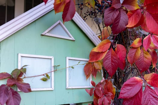 Decorative wooden house in the autumn garden.