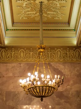 luxury expensive chandelier hanging under ceiling in palace.