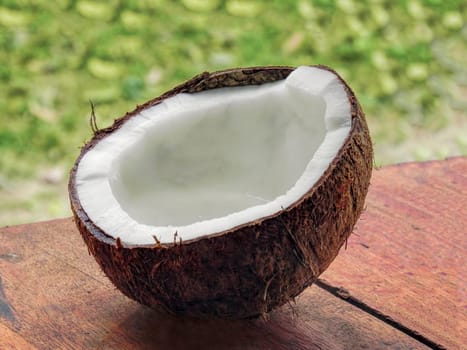 chopped coconut with juice on wooden background close-up