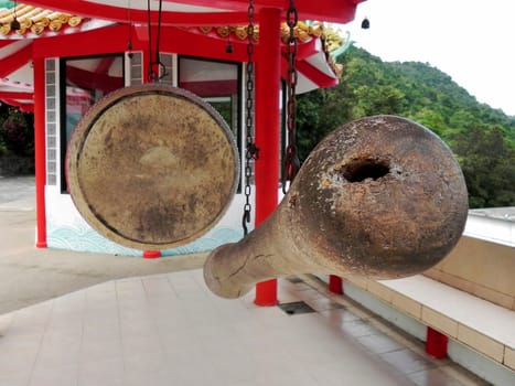 a drum and a baton hang in a Chinese templein Thailand.