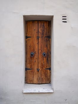 old wooden window shutters on a white wall.