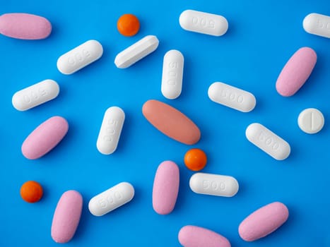 Colored pills on a blue background top view