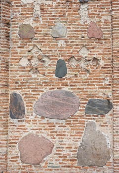 Old fortress wall of red brick interspersed with large cobblestones