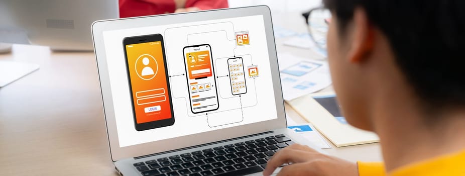 Panorama banner of startup UX developer or company employee design user interface or UI prototype for mobile application or website software with software display on laptop monitor in office. Synergic