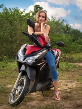 tanned girl Caucasian nationality driving a red motorcycle .journey on a scooter.