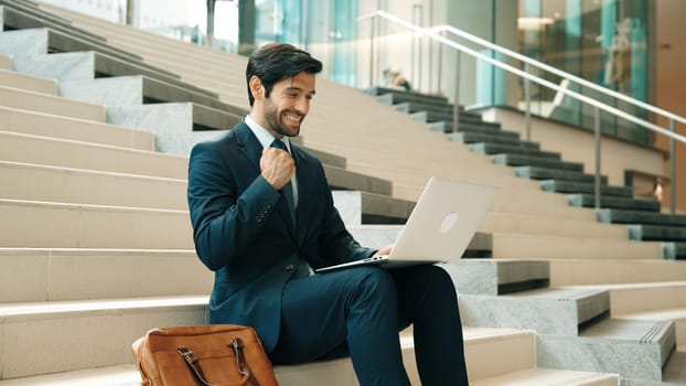 Executive manager celebrate successful project or getting promotion, getting new job. Professional business man express feeling joy and happy while using laptop checking increasing sales. Exultant.