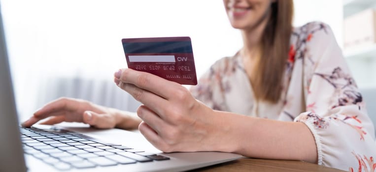 Close up credit card using for online payment, banking and shopping on the internet network with laptop computer showing credit card technology for online secured wallet top up and utmost purchase