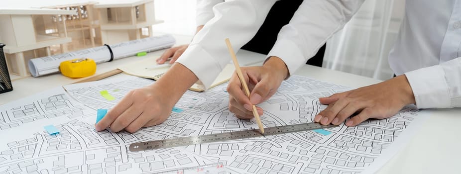 Worker, architect and engineer work on real estate construction project oratory planning with cartography and cadastral map of urban town area to guide to construction developer business plan of city