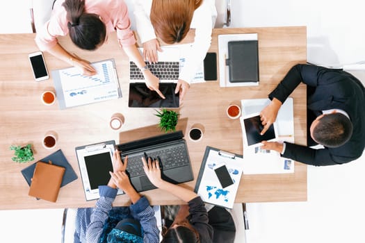 Top view of businessman executive in group meeting with other businessmen and businesswomen in modern office with laptop computer, coffee and document on table. People corporate business team uds