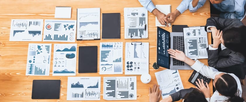 Panorama top view multiracial analyst team use BI dashboard display on laptop screen, analyzing financial data for strategic decision. Fintech analyzes marketing indicators. Concord
