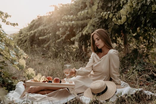 Picnic and wine tasting at sunset in the hills of Italy, Tuscany. Vineyards and open nature in the summer. Romantic dinner, fruit and wine.