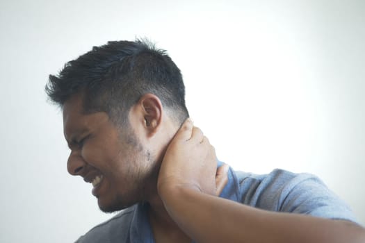 man suffering chronic neck pain .