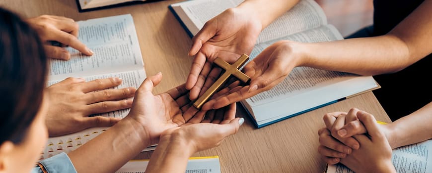 Close-up women prayer deliver holy bible book and holy cross to believer group. Spreading religion symbol. Concept of hope, religion, christianity and god blessing. Warm background. Burgeoning.