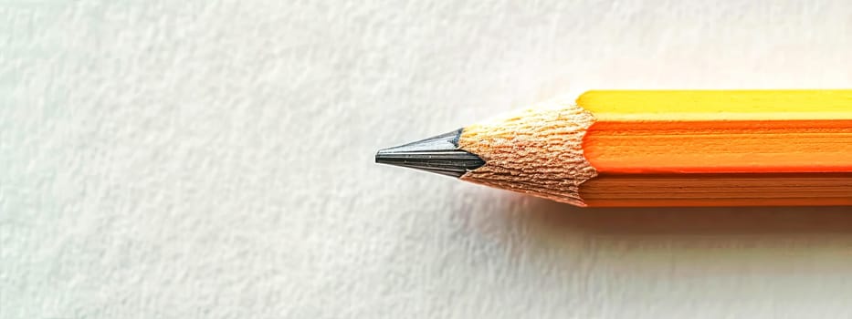 sharpened orange pencil against a white background, emphasizing the texture of the wood and graphite, with a clear focus on the pencil's tip. copy space