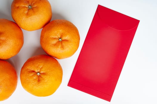 Chinese New Year red envelope and Mandarin oranges with customizable space for text or greetings. Copy space.