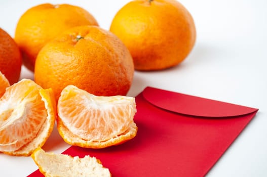 Pealed Mandarin orange on top of Chinese New Year packet.