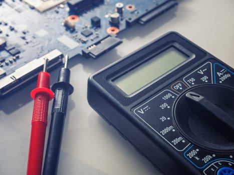 Multimeter test, electronic board of digital device with components. Troubleshoot electronic device. Computer and mobile device repair concept