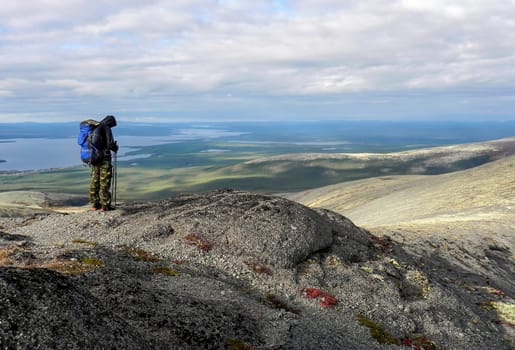 Man on the top of the mountain. Hiker with a backpack on the mountain. Conceptual design.
